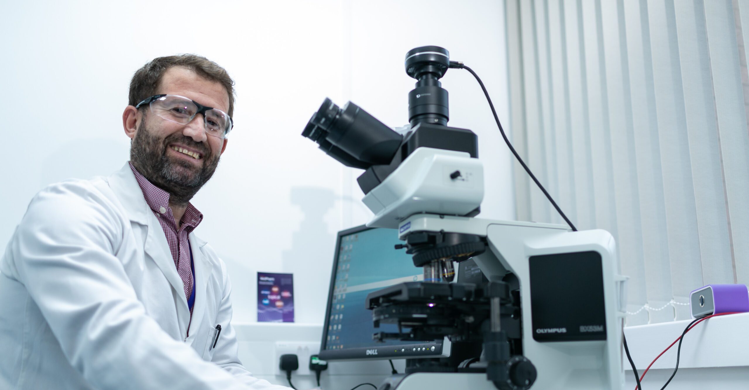Scientist performing analytical testing using microscopy for topical and transdermal drug products